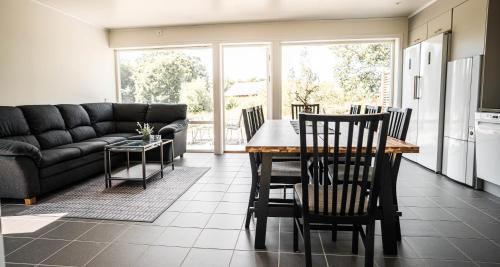 a kitchen and living room with a table and chairs at Saxnäs Ferieboende L Sara in Färjestaden