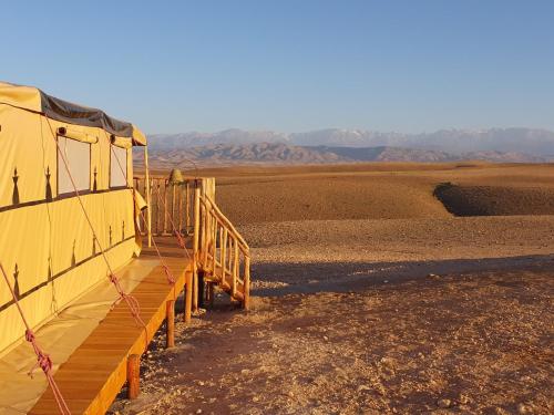 a yellow building in the middle of the desert at Nkhila Lodge in Marrakech