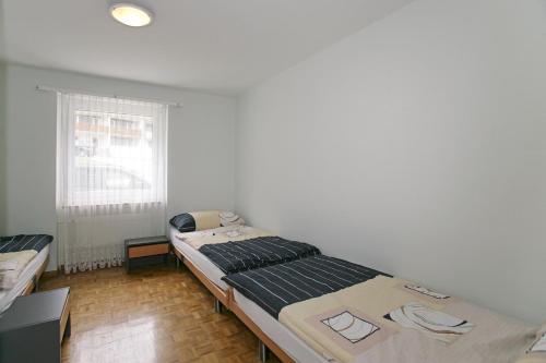 a bedroom with a large bed and a window at Apartments Haus Quelle in Leukerbad