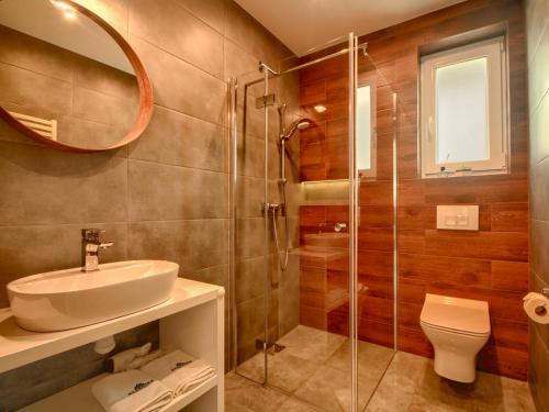 een badkamer met een wastafel, een toilet en een spiegel bij Apartamenty Szarotka in Wisła