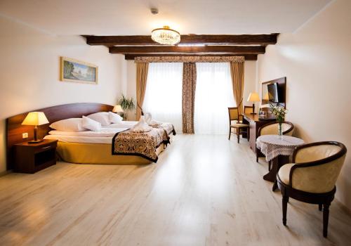 1 dormitorio con 1 cama, mesa y sillas en Dwór Niemierzyce en Granowo