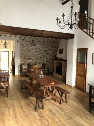 a living room with a wooden table and a fireplace at La Casa de la Abuela in Villarta de San Juan