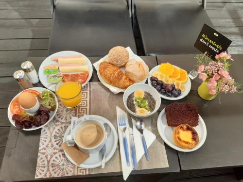 a table topped with plates of food and drinks at Hotel Gat Rossio in Lisbon