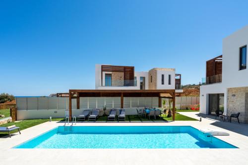 a villa with a swimming pool and a house at Lux Villa Nymphes Dioni, 30m from beach with Pool, BBQ and Play Area in Stavromenos