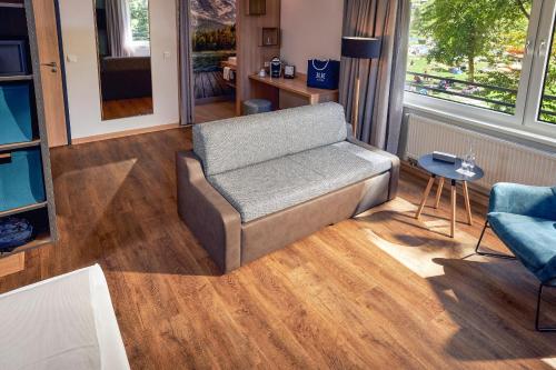 a living room with a couch and a table at TUI BLUE Montafon in Schruns-Tschagguns