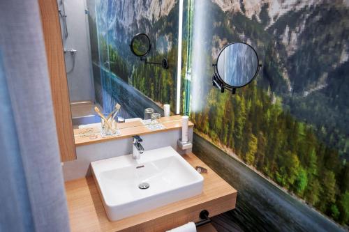 a bathroom with a sink and a mirror at TUI BLUE Montafon in Schruns