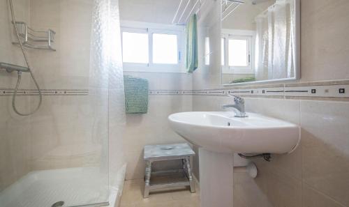 een witte badkamer met een wastafel en een douche bij TarracoHomes-TH123 Apartment with sea view terrace in Cala Romana in Tarragona