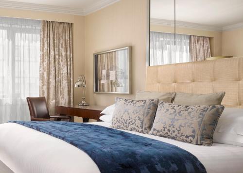 a bedroom with a large bed and a desk at InterContinental London Park Lane by IHG in London