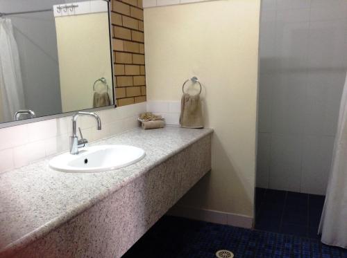 a bathroom with a sink and a mirror at Winchester Motel in Moree