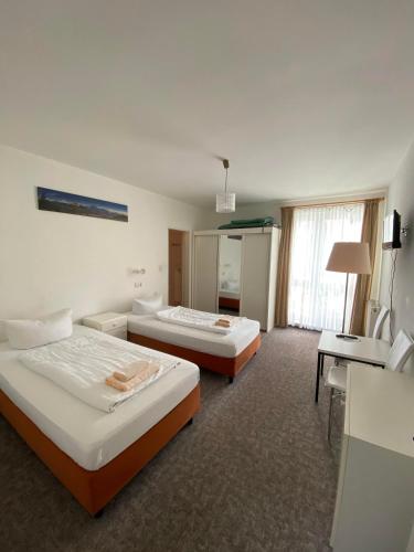 a hotel room with two beds and a desk at Hotel Seehaus in Horn-Bad Meinberg