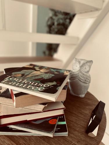 a pile of books sitting on top of a table at Lichtrijke loft bij restaurant Den Olifant in Ypres