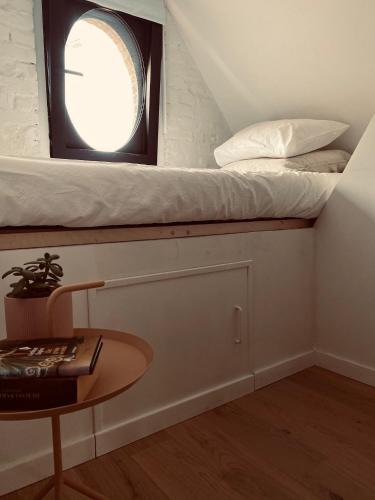 a small room with a bed and a table at Lichtrijke loft bij restaurant Den Olifant in Ypres