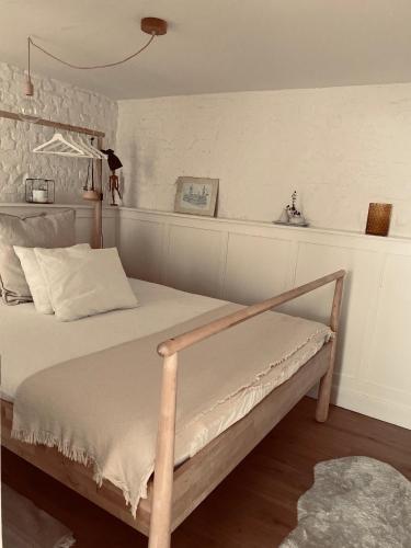 a bedroom with a bed with a wooden frame at Lichtrijke loft bij restaurant Den Olifant in Ypres