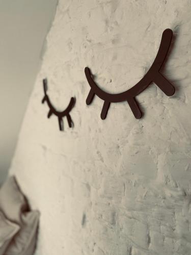 two wooden signs hanging on a white wall at Lichtrijke loft bij restaurant Den Olifant in Ypres