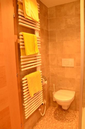 a bathroom with yellow towels and a toilet at Kleintödlinggut in Leogang