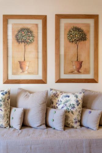 a couch with pillows and two pictures on the wall at Vencia Boutique Hotel in Mýkonos City