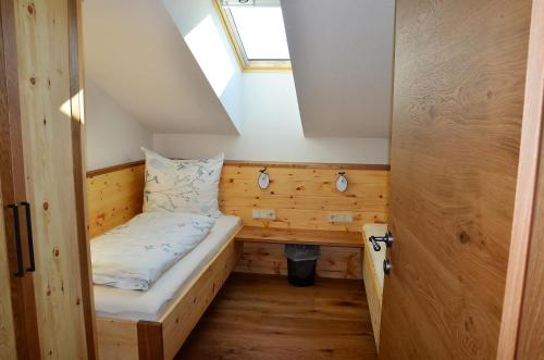 a small room with a bed and a window at Kleintödlinggut in Leogang