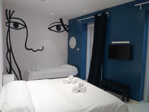 a bedroom with two beds and a painting of a face at San Giorgio Modica Hotel in Modica