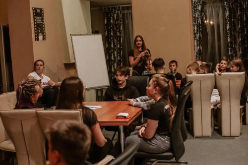 a group of people sitting around a table in a room at Gala Hotel in Kamianets-Podilskyi