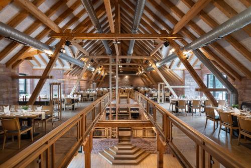 comedor con techos de madera, mesas y sillas en ClassicX Landhaus & Hotel - Bed & Breakfast, en Gensingen