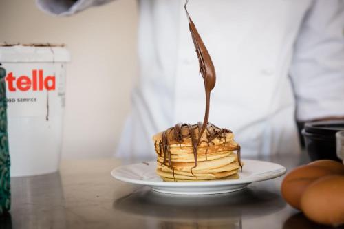 a person is eating a piece of cake on a plate at Hotel Giulia in Lido di Camaiore