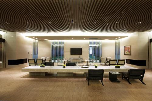 a lobby with a large table with chairs and a television at The Classic 500 Pentaz Executive Residence in Seoul