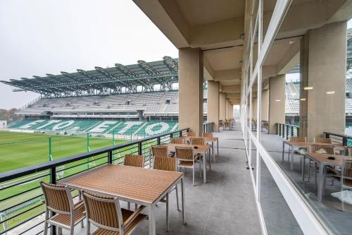 a cafeteria with tables and chairs in a baseball stadium at ETO Park Hotel Business & Stadium in Győr