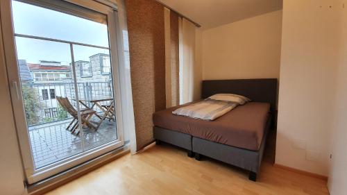 a bedroom with a bed and a large window at Wiener Maisonette mit Terrasse in Vienna