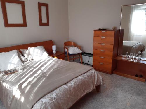 1 dormitorio con 1 cama con cómoda y silla en Casa Montelouro, en Muros