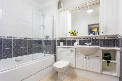 a bathroom with a toilet and a sink and a bath tub at Millbrae Residence - Donnini Apartments in Ayr