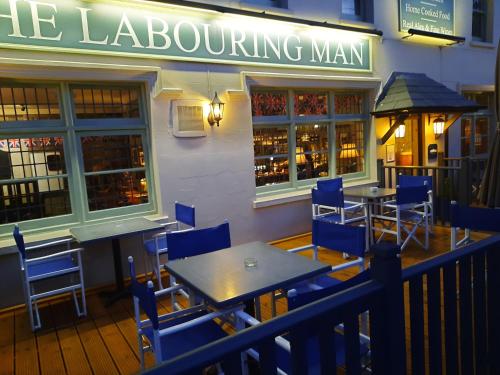 een tafel en stoelen voor een restaurant bij The Labouring Man in Coldwaltham