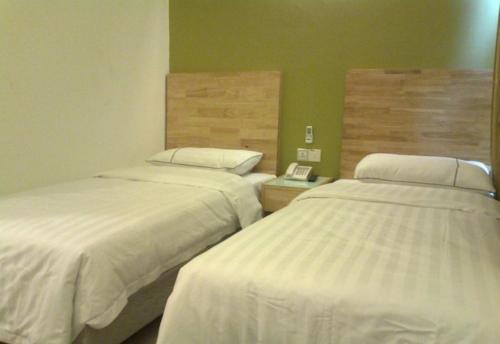 a room with two beds and a telephone in it at Hotel Desaria in Petaling Jaya