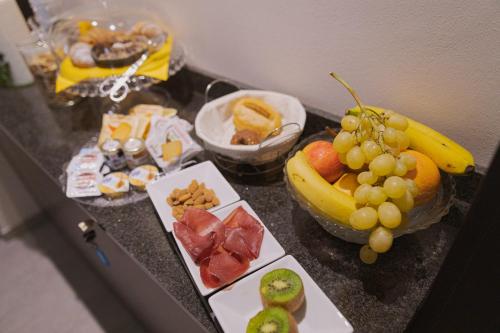 a bunch of fruit on a counter with a bowl of grapes at La Maison Di Carla in Ancona