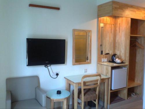 فندق ديزاريا في بيتالينغ جايا: غرفة معيشة مع طاولة وتلفزيون على الحائط