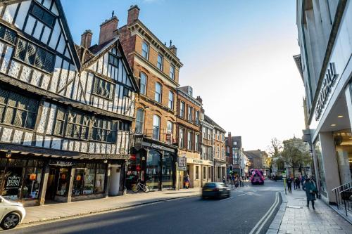 a city street with buildings and a car on the road at 2 Rowntree House in York