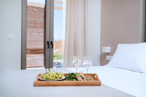 a tray of fruit and wine glasses on a bed at Lux Villa Nymphes Dioni, 30m from beach with Pool, BBQ and Play Area in Stavromenos
