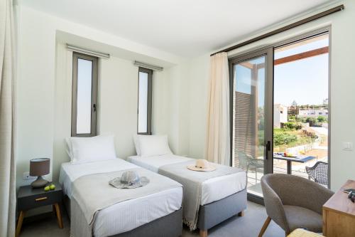 a hotel room with two beds and a balcony at Lux Villa Nymphes Dioni, 30m from beach with Pool, BBQ and Play Area in Stavromenos