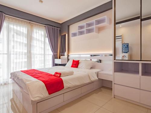 a bedroom with a large bed with red pillows at RedLiving Apartemen Gateway Pasteur - TN Hospitality 1 Tower Jade B in Bandung