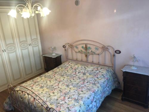1 Schlafzimmer mit einem Bett mit Blumenbettdecke in der Unterkunft B&B Damiano in Crespano del Grappa