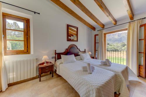 a bedroom with two beds and a window at Villa Vall Den March II in Pollença