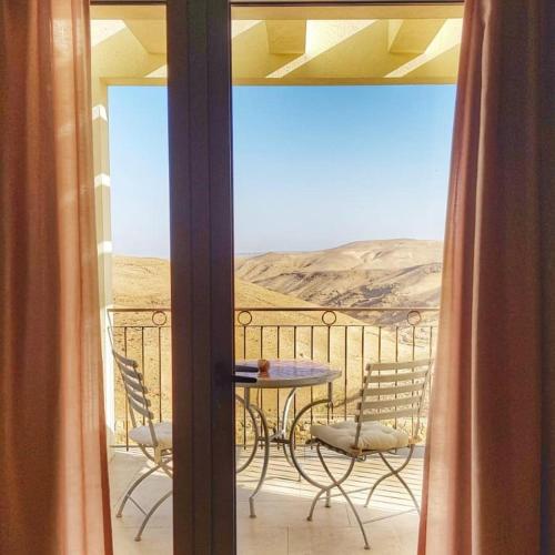 a patio with a table and chairs on a balcony at Yehelim Boutique Hotel in Arad