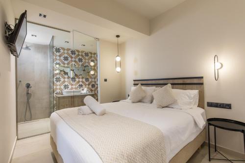 a bedroom with a large white bed and a shower at Venezia Luxury Living Villas, Faliraki in Faliraki