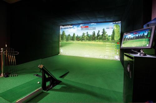 a room with a golf simulator with a tv and a golf course at The Classic 500 Pentaz Executive Residence in Seoul