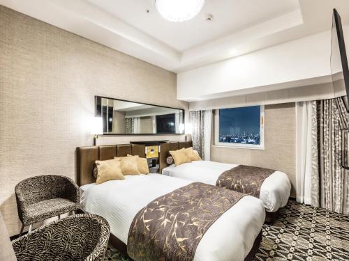 a hotel room with two beds and two chairs at APA Hotel & Resort Ryogoku Eki Tower in Tokyo