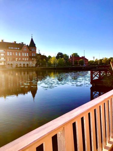 a large body of water with a building and a bridge at Stugan med Bryggan i Gamla Staden in Eskilstuna