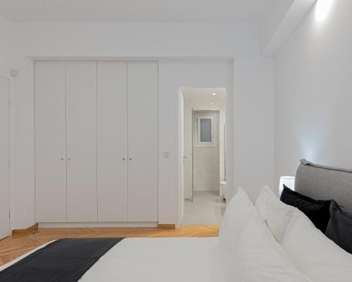 1 dormitorio con paredes blancas y 1 cama blanca en Kolonaki Luxury Residence, en Atenas