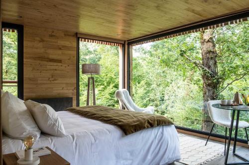 um quarto com uma cama e uma grande janela em Loire Valley Lodges - Hotel em Esvres