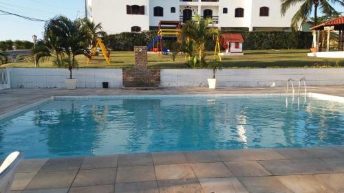 an empty swimming pool in a resort with palm trees at Vista Panorâmica em São Pedro da Aldeia in Rio de Janeiro