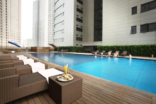 a swimming pool with chairs and people in a building at The Classic 500 Pentaz Executive Residence in Seoul