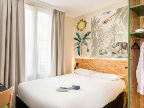a hotel room with a bed with a towel on it at ibis Styles Paris Boulogne Marcel Sembat in Boulogne-Billancourt